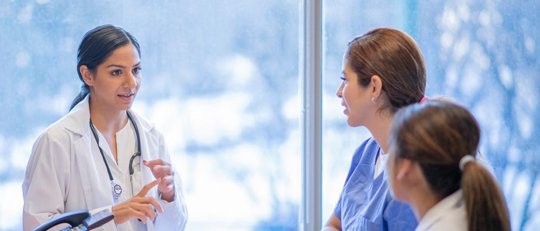A doctor is having a converstion with two other medical staff.