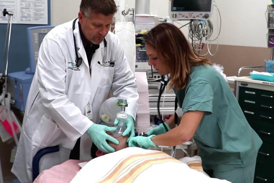 An emergency department resident works with a patient.