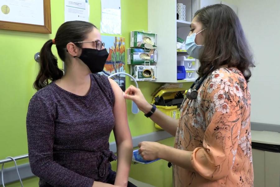 A doctor uses an antiseptic cotton swab to sterilize a spot on a patients arm before administering an injection.