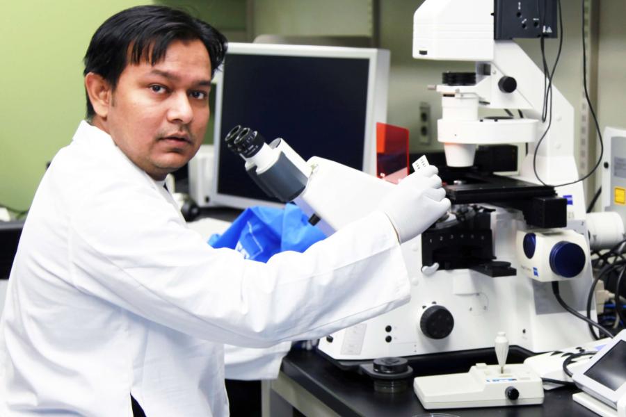 A resident looks at a slide using a microscope