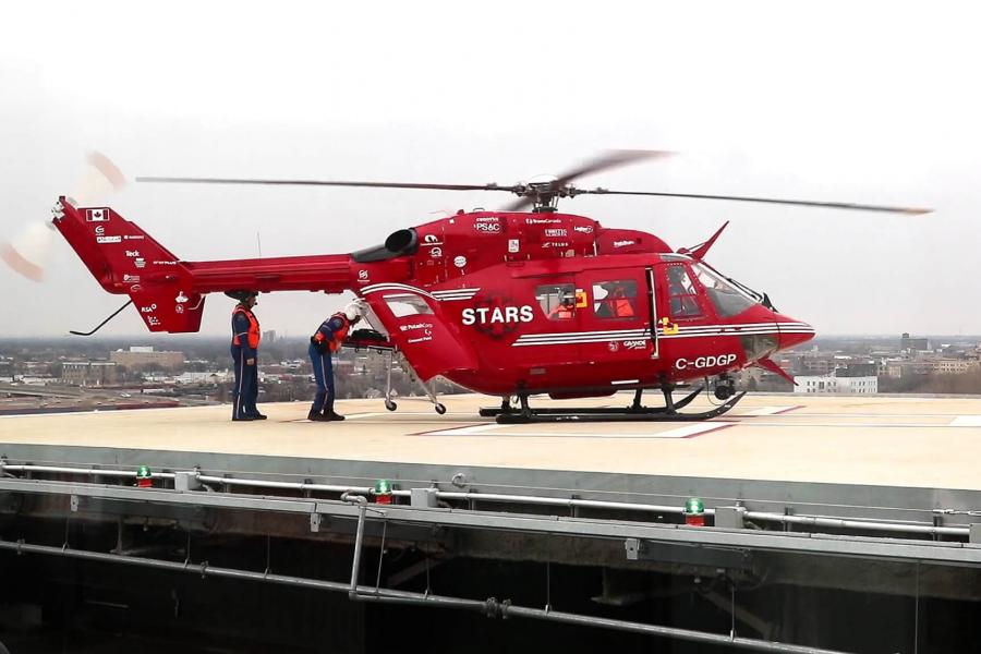 medical professionals work to unload a stretcher from a helicopter.