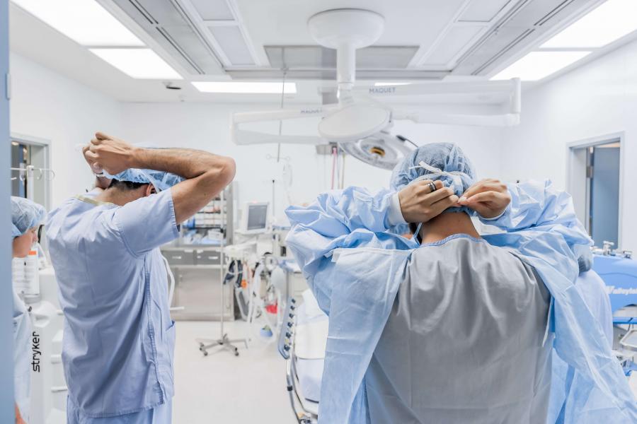 Surgeons tying on masks.