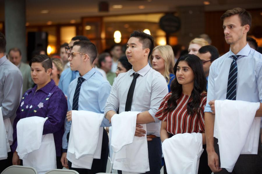 Students receive their white coats.