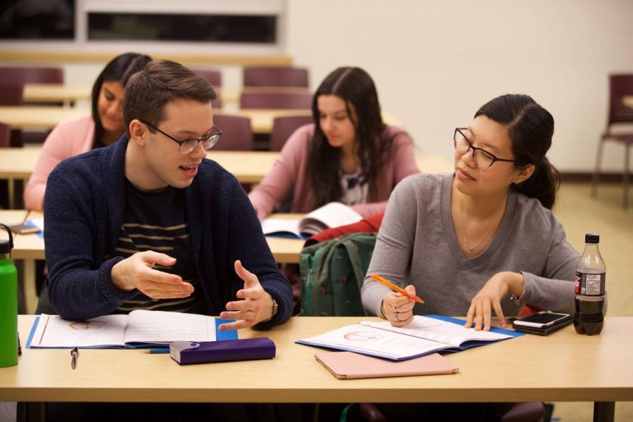 Students discussing an assignment in a classroom setting.