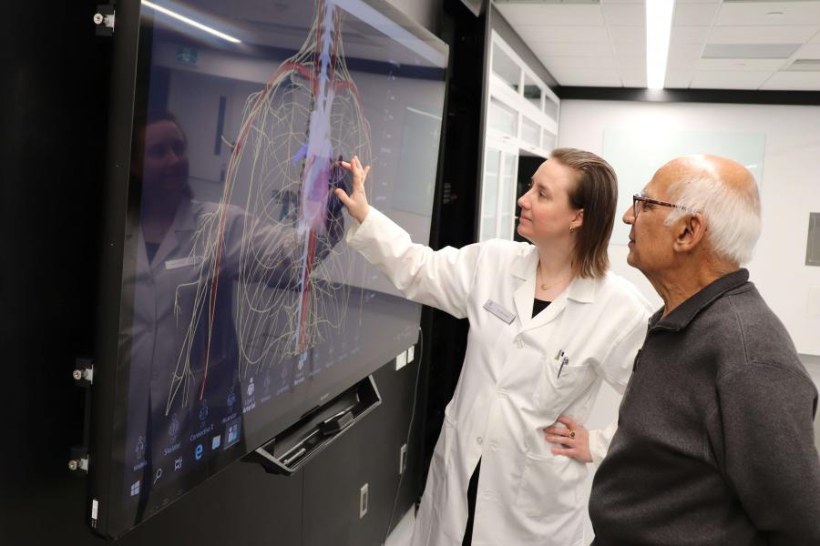 A lab technician demonstrates a touch screen.