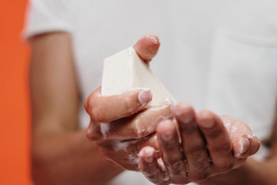 Washing hands with a bar of soap.