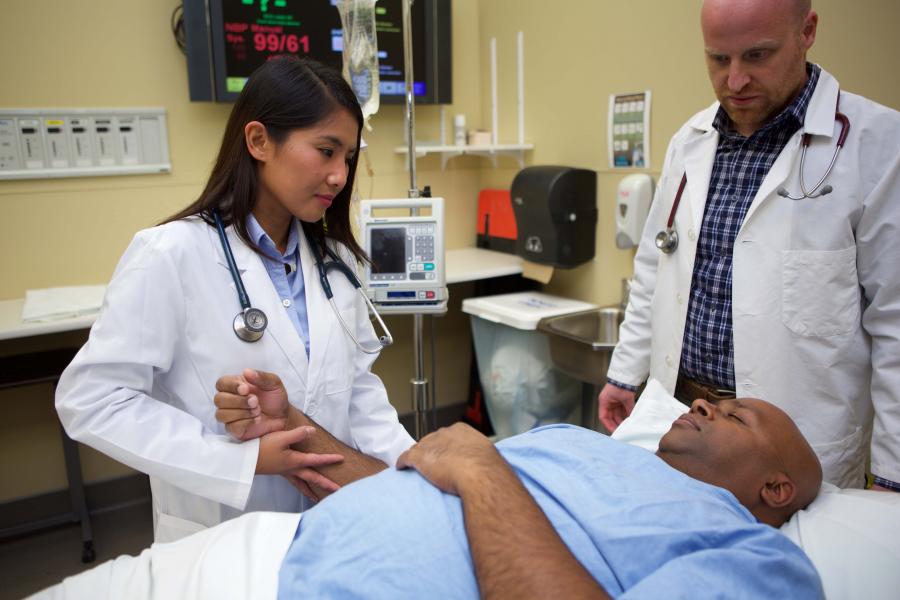 Two physician assistants assess a patient
