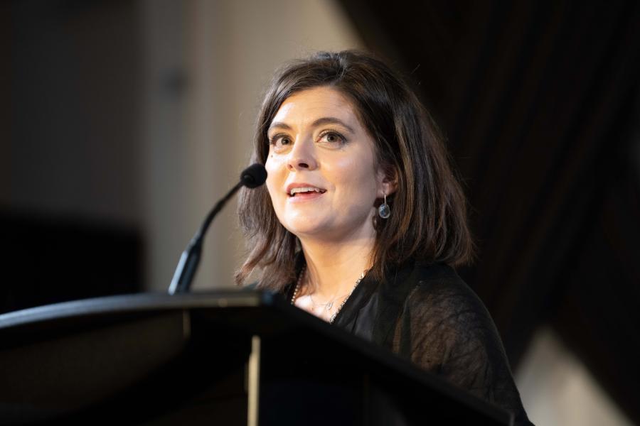 Rebecca Mueller speaks at a podium during an event