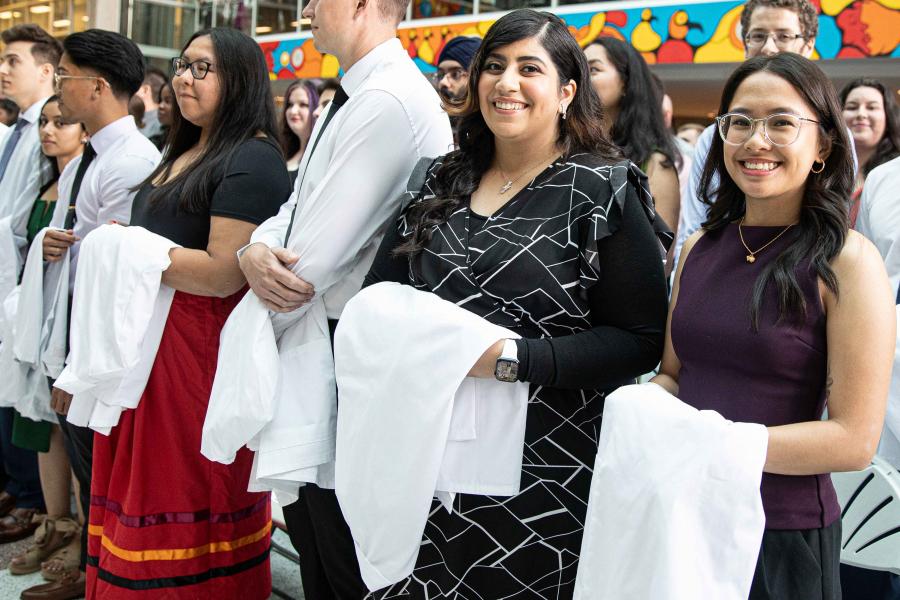 Med students with their white coats draped over their arms, during inaugural day excercises.