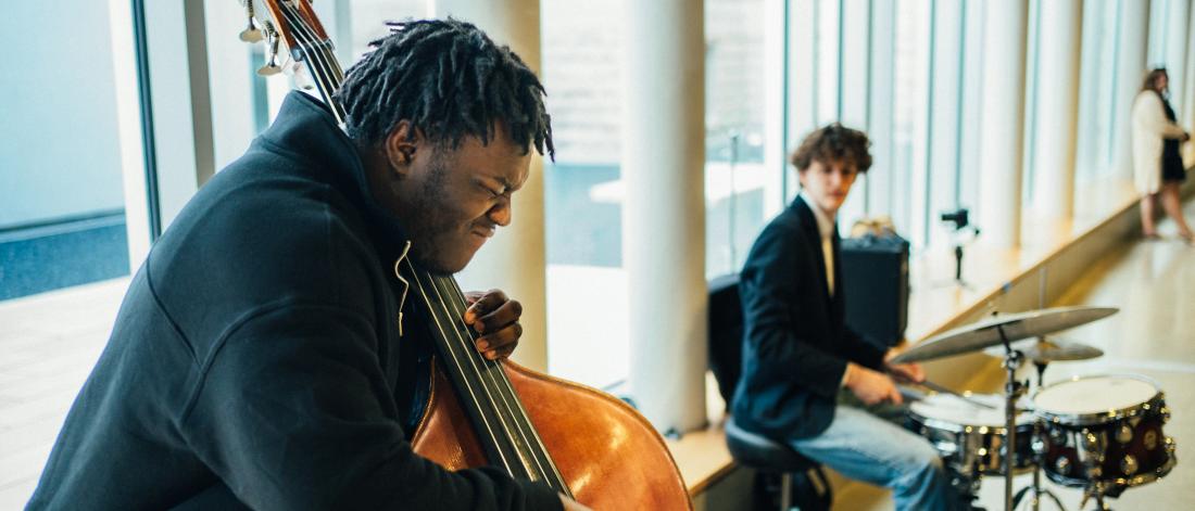 man playing a double bass and man playing drums