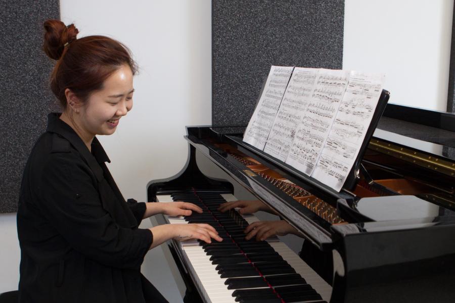 A faculty of music student plays the piano.