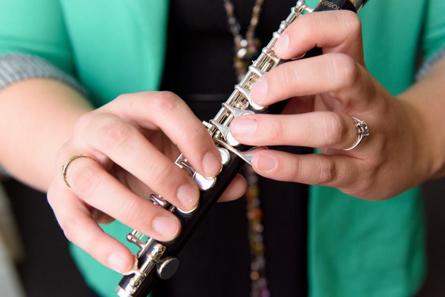 A pair of hands holding a flute.