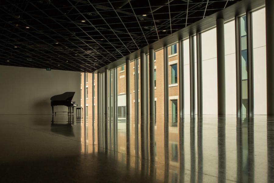 An interior view of the Tache atrium with a grand piano in the back corner of the space.