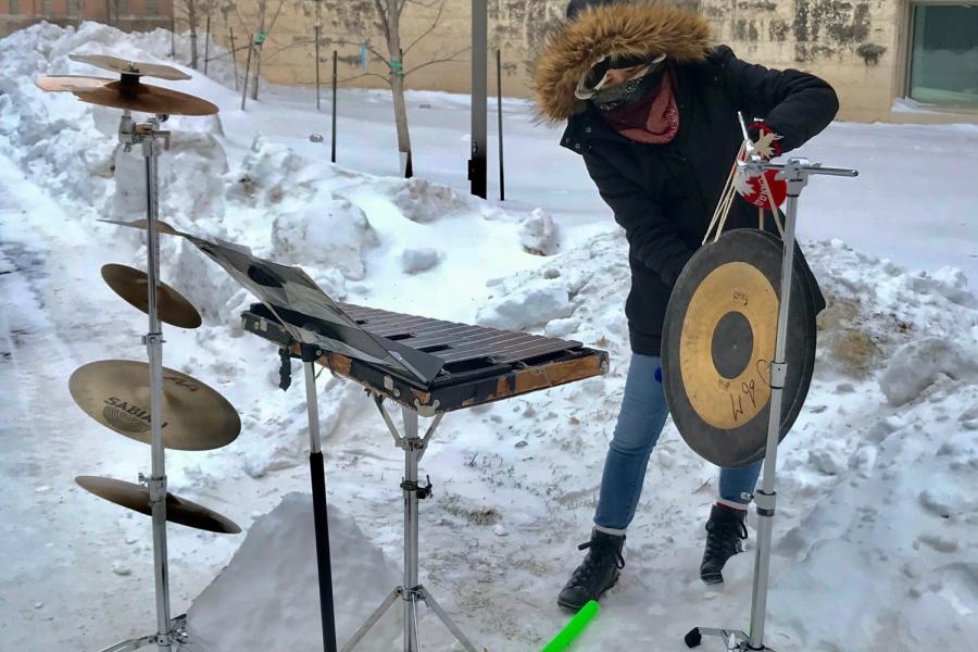 A study in winter gear performs a midday concert outside in the middle of winter
