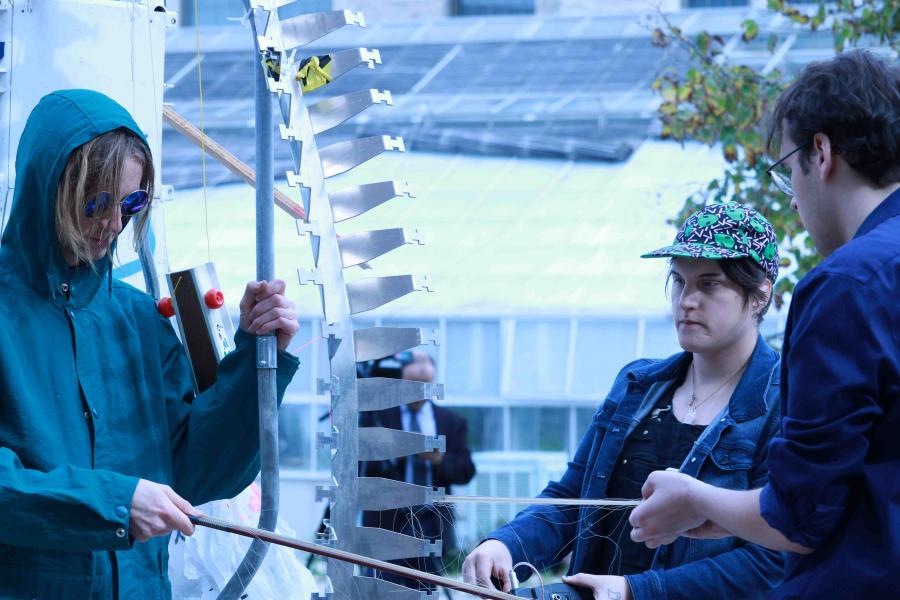 Composition students perform improvisational compositions using objects as instruments during a climate demonstration.