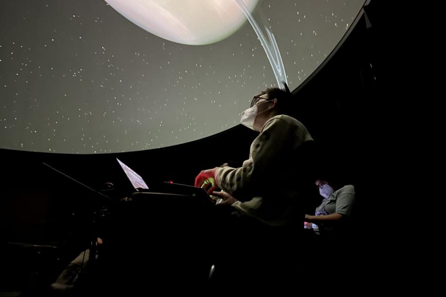 A composer looks towards the ceiling of the UM Lockhart Planetarium during an improvisational composition concert.