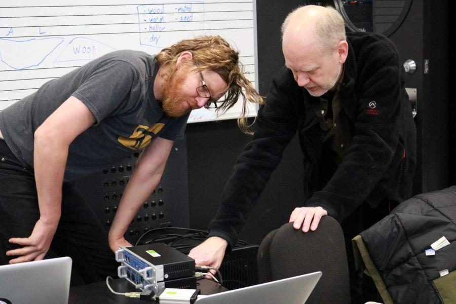 Composition professor Orjan Sandred shows a composition student how to adjust touch-sensitive equipment prior to an interactive installation that explores the sounds of ice..