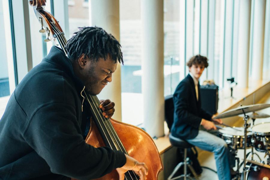 Student playing bass with another playing drums