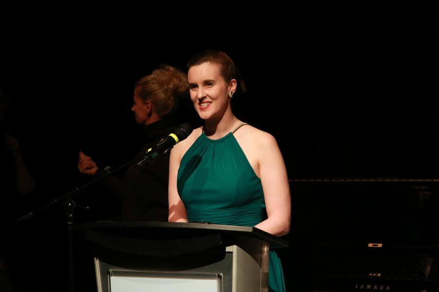 Desautels student addressing a crowd from a podium