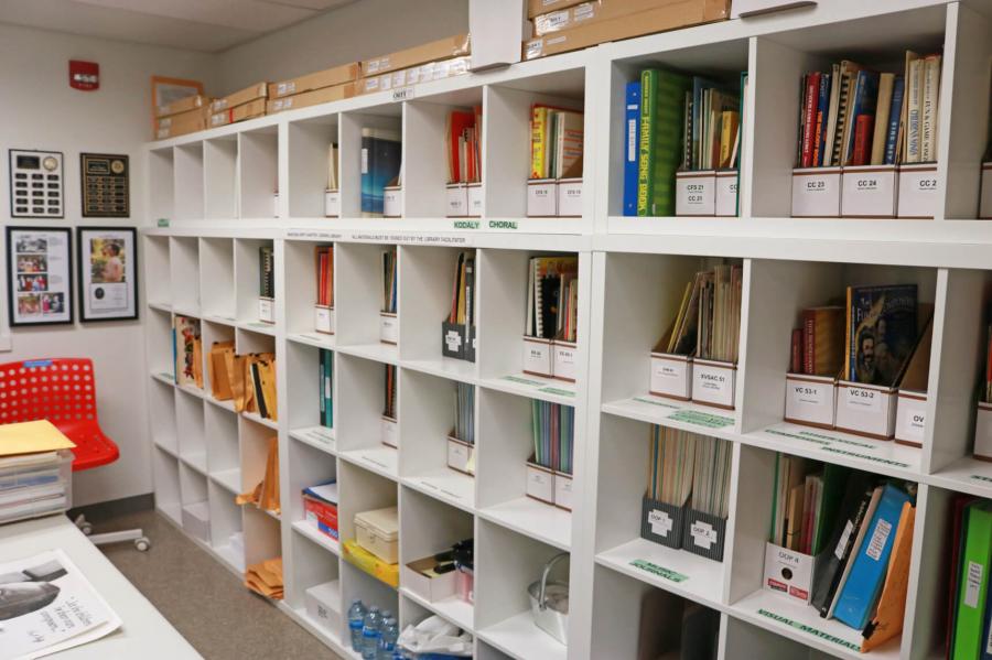 A portion of the interior of a room with a wall lined with shelving holding various pedagogy literature and materials.