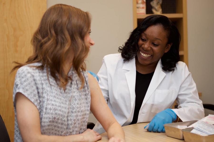 A Pharmacist giving a community member a flu shot.