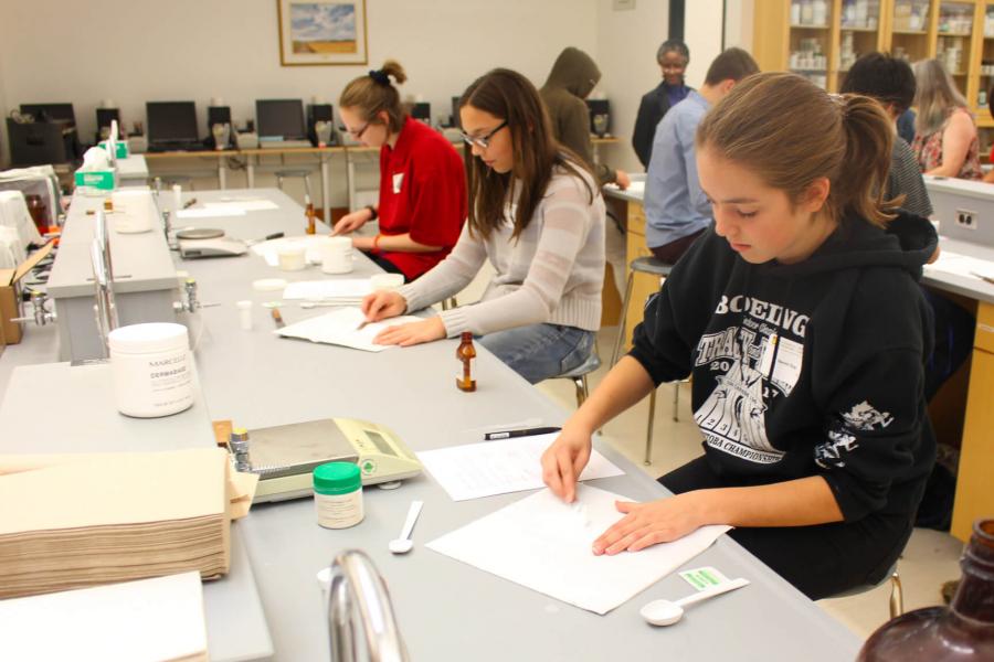 Highschool students participating in Take Your Kids to Work Day sit at desks and work individually in the undergraduate wet lab.  