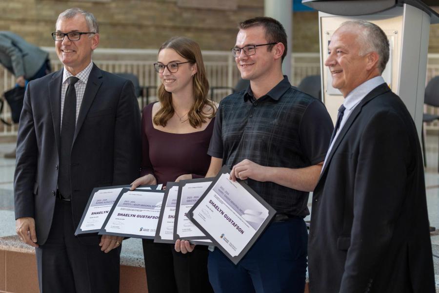 Two pharmacy students pose for a photo as they are each presented an award.