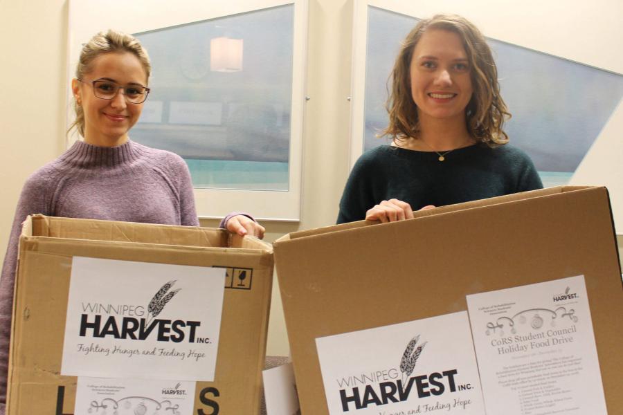 Students donating boxes of groceries to Winnipeg Harvest