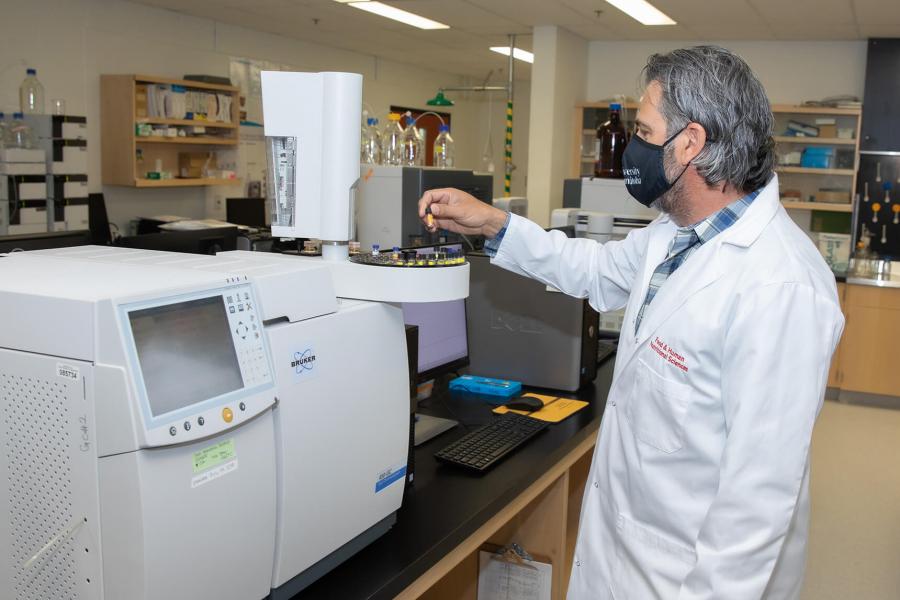 A technician examines a sample in a lab.