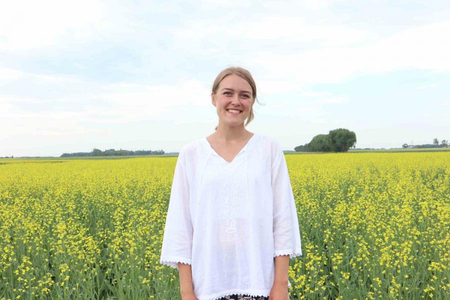 Lettie, student in Genetics, standing in a field.
