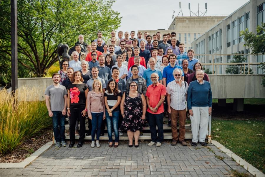A diverse group of people in the department of physics and astronomy posing for a photo outside.