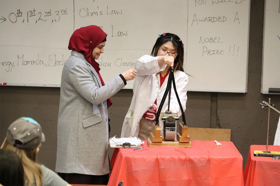 Two women performing a physic experiment at the Physics Show at Science Rendezvous.