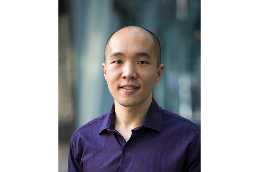 Jimmy Zhu wearing a navy blue long sleeve smiling at the camera.