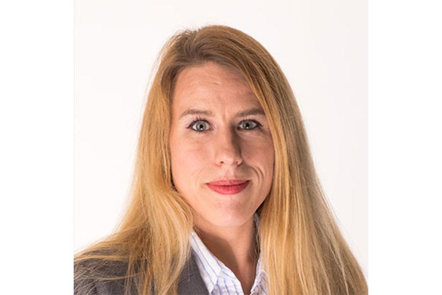 Karen Gunderson wearing a gray coat and smiling at the camera.
