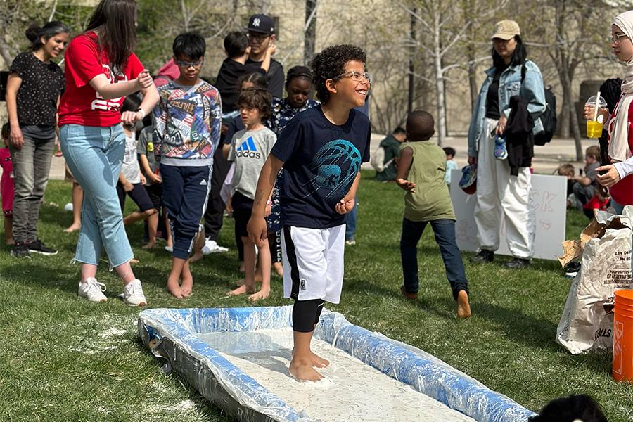 A kid having fun at the oobleck run and smiling at everyone.