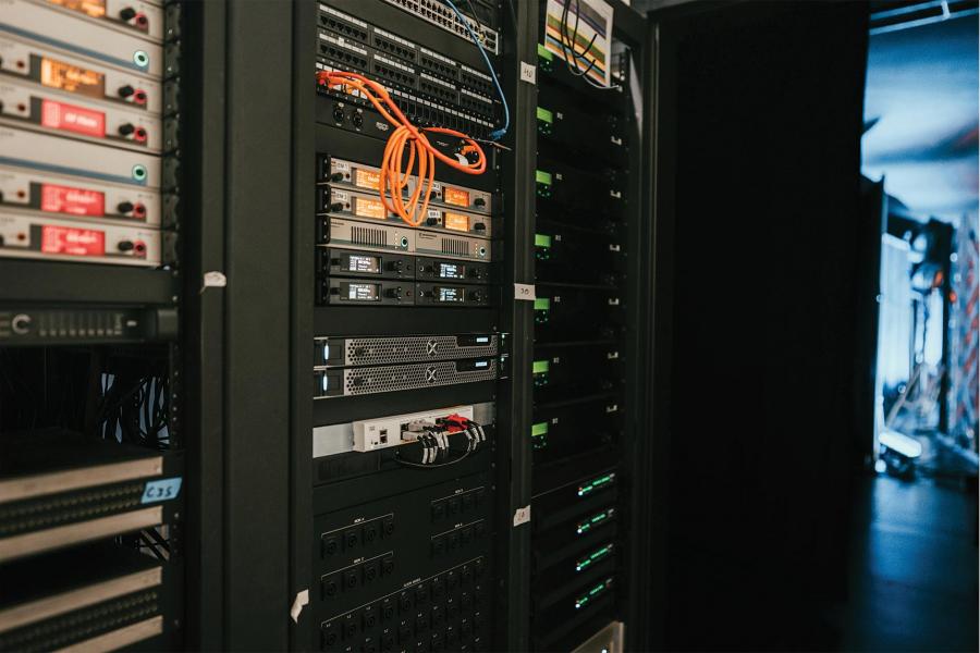 Wired server racks equipped with networking gear, patch panels, and active indicators.