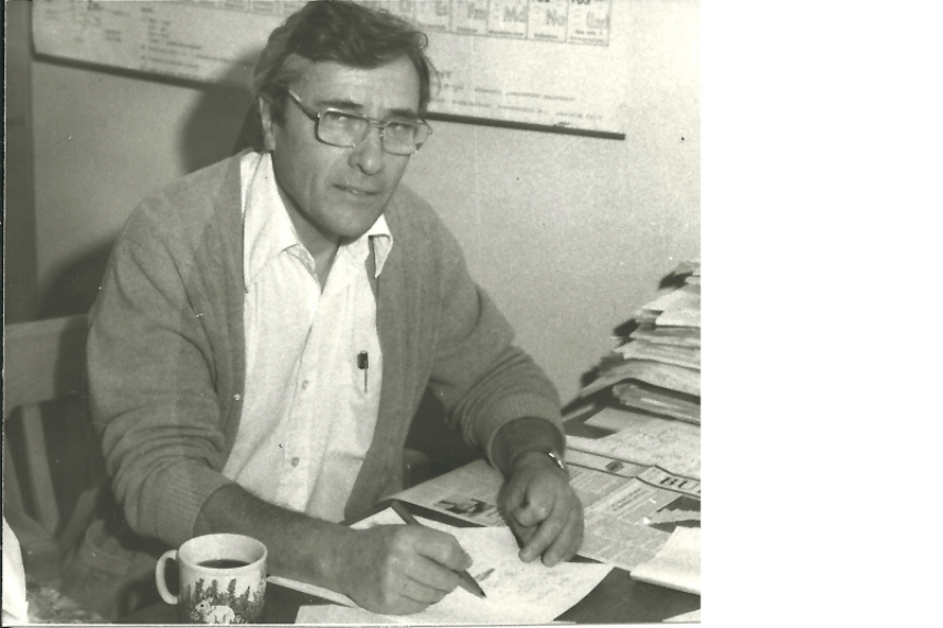 Ernst Bock looking at the camera while holding a pen. The photo is in sepia color.