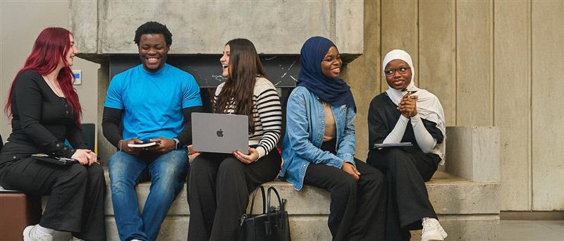 Group of students sitting and smiling together.