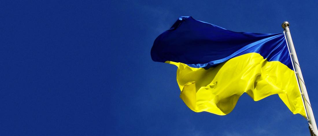 The Ukrainian flag flying in the wind. The flag consists of two horizontal bands: the top one is blue and the bottom one is yellow.