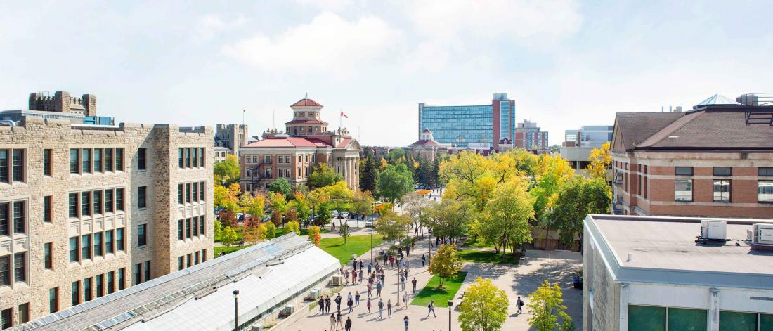 A semi-arial image of UM Fort Garry campus in summer, during the day, where various buildings and people are seen walking.