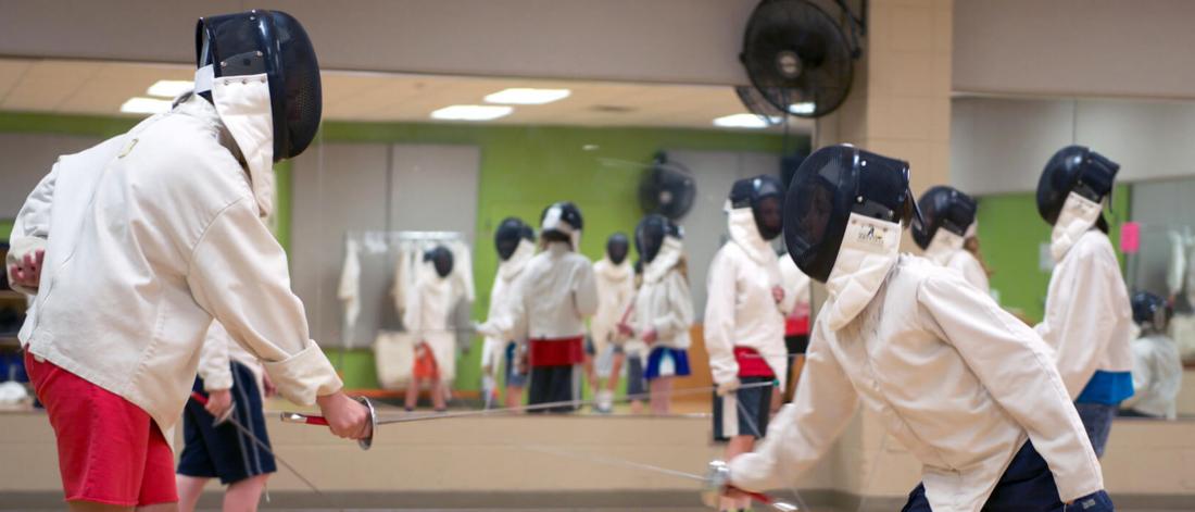 Pre-teens try fencing during summer camp.