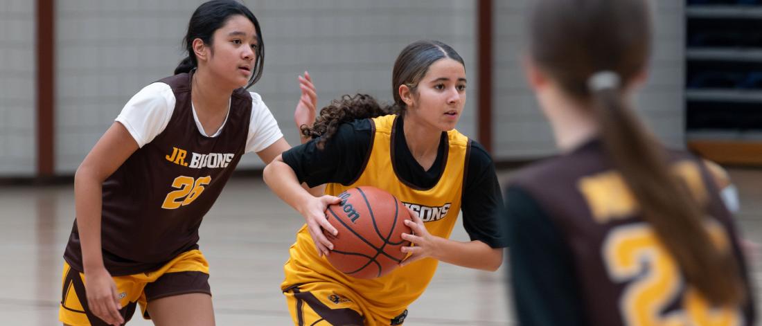 Two girls in a Junior Bisons basketball practice game.