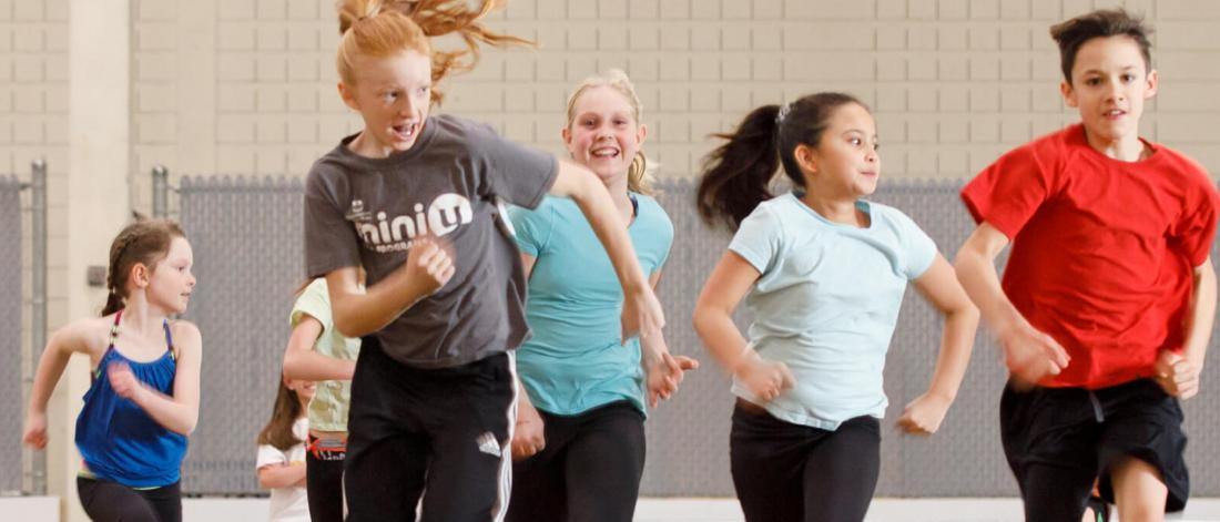 Children run on an indoor track.