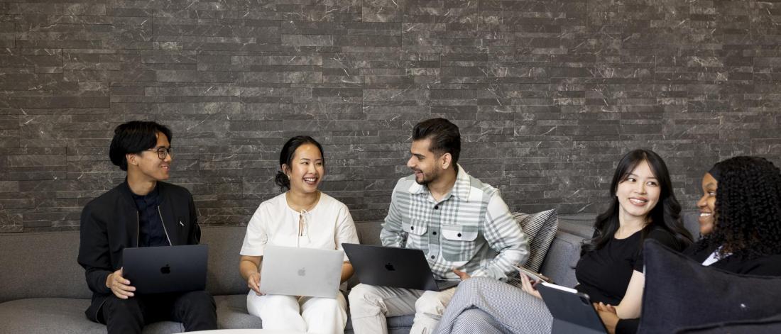 students sitting with their laptops in a discussion