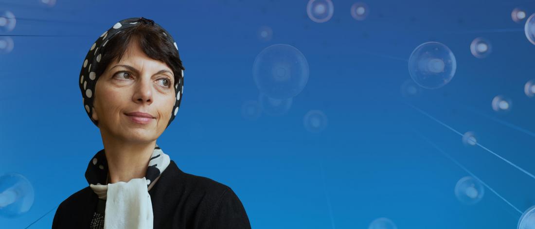 Portrait of Zahra Moussavi looking to the side, set against a blue background with abstract circular light elements.