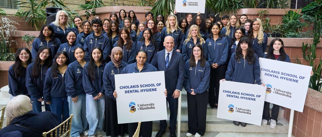  A group of students stand around UM alum Dr. Ernest Cholakis 