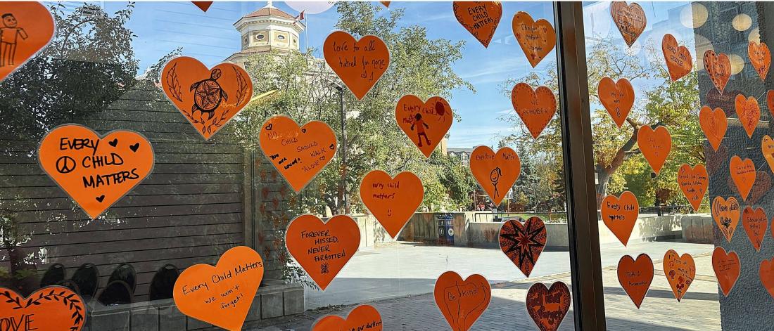 Cut out orange hearts with written notes including "Every child matters"