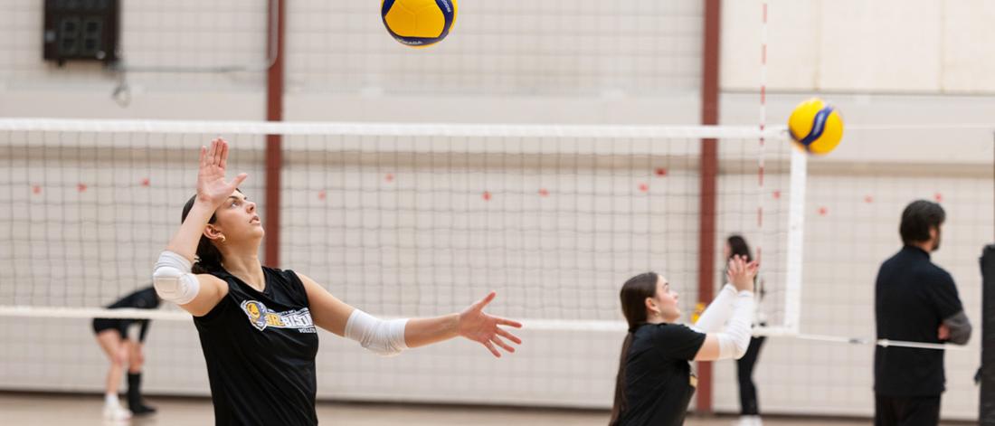 A junior Bisons volleyball player rallies the ball during practice.
