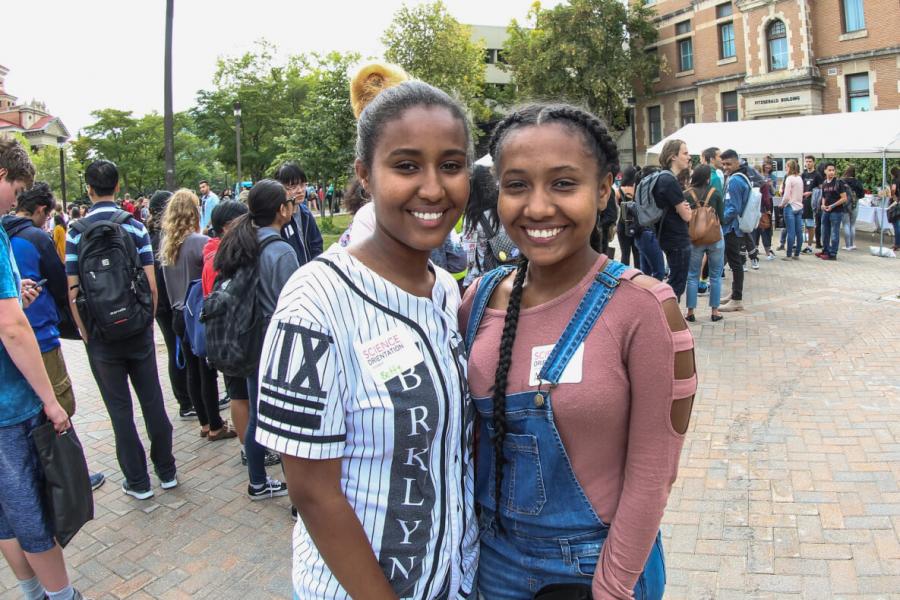 two students smiling on campus outdoors 