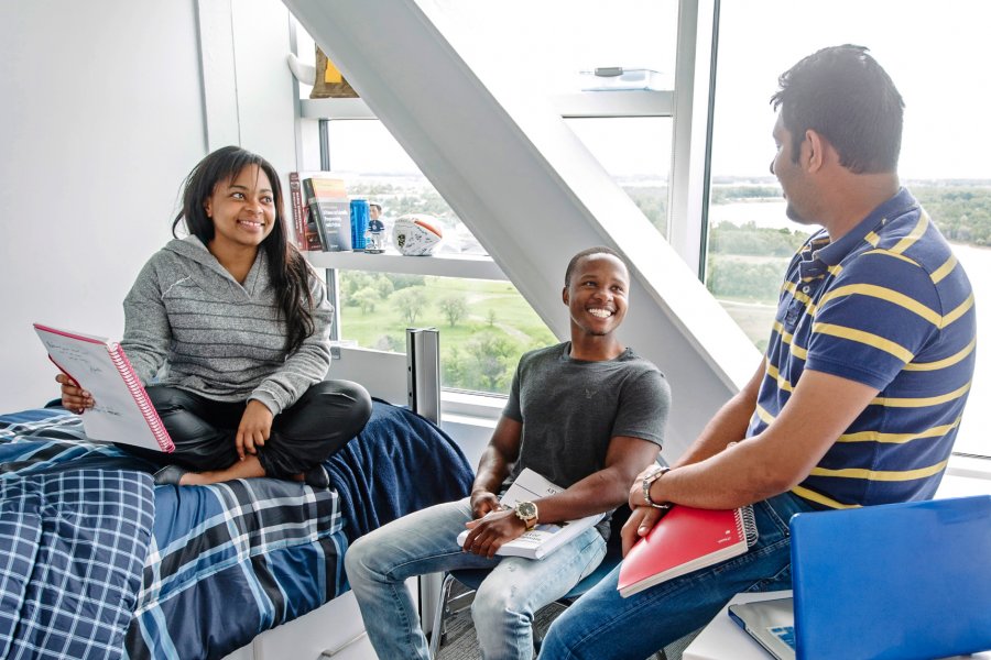 Three University of Manitoba students sitting in a Pembina Hall Residence room.